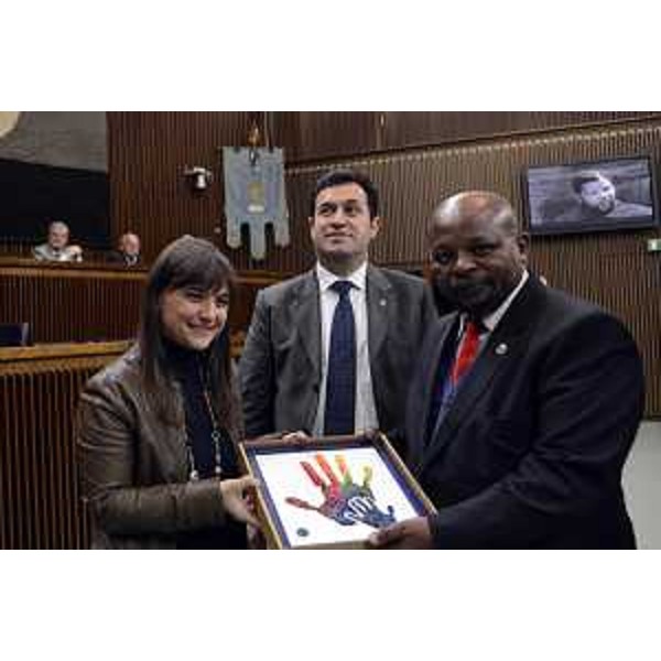 Debora Serracchiani (Presidente Regione Friuli Venezia Giulia) e Franco Iacop (Presidente Consiglio regionale FVG) consegnano il mosaico della Scuola spilimberghese, che il FVG dona al Sudafrica, a Saul Kgomotso Molobi (Console generale Repubblica Sudafrica a Milano), durante le celebrazioni del Consiglio regionale in ricordo di Nelson Mandela, a 20 anni dall'elezione a presidente del Sudafrica - Trieste 12/12/2014