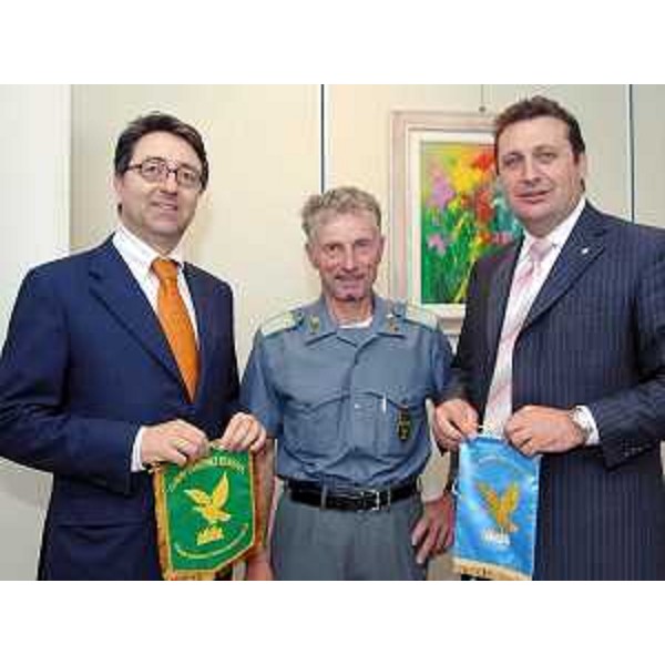 Enzo Marsilio (Assessore regionale alle risorse agricole, naturali, forestali e montagna) consegna il gagliardetto FVG al forestale Mario Cedolin in procinto di partire per il K2 con Nives Meroi (14/06/06)