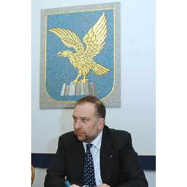 Roberto Cosolini (Assessore regionale al lavoro, formazione, università e ricerca) - Mezzobusto con lo stemma della Regione alle spalle 