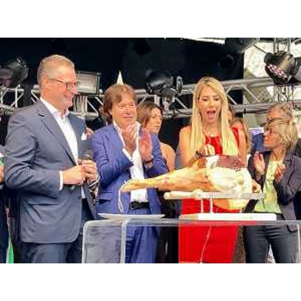 L'assessore Bini assiste al tradizionale taglio del prosciutto. A destra la madrina di Aria di Festa 2023 Giorgia Rossi - L'assessore Bini assiste al tradizionale taglio del prosciutto. A destra la madrina di Aria di Festa 2023 Giorgia Rossi