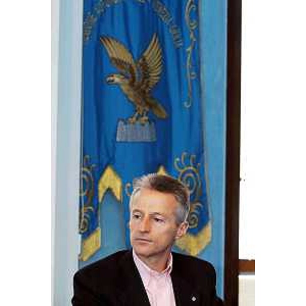 Riccardo Illy (Presidente Regione Friuli Venezia Giulia) ritratto a 'mezzo busto' con il gonfalone della Regione Autonoma Friuli Venezia Giulia